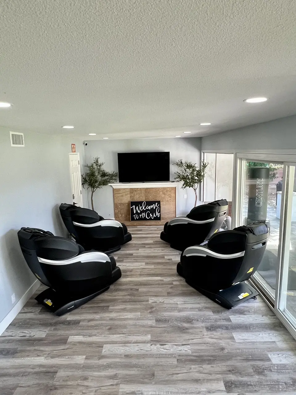 substance use disorder rehab residential living room. There are four couches and a flat screen tv on the wall above a fireplace