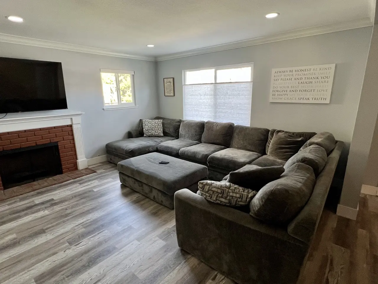 substance use disorder rehab residential living room. There are four couches and a flat screen tv on the wall above a fireplace