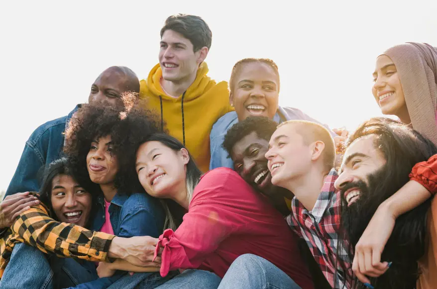 A diverse group of friends sitting outside laughing together