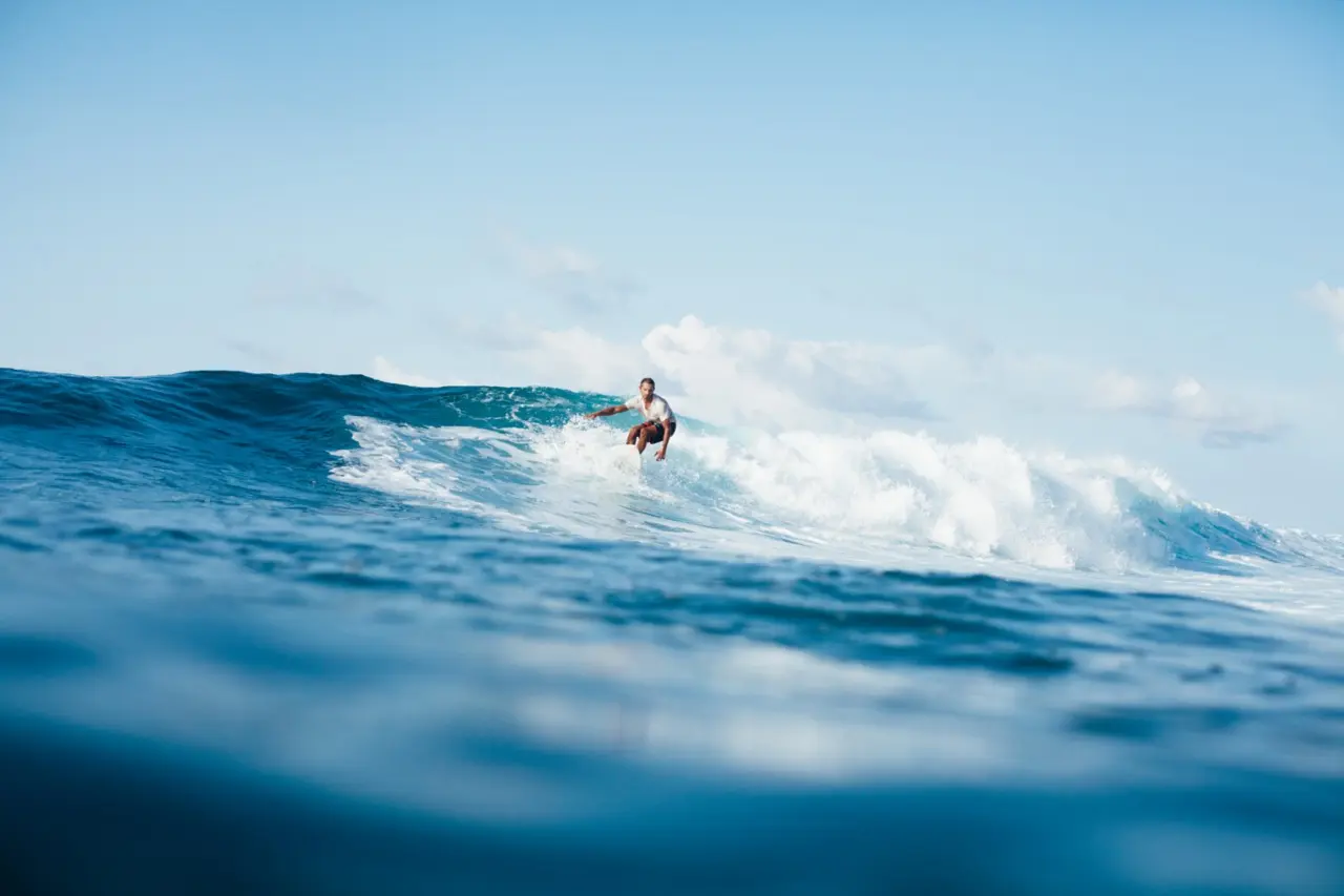 Man surfing on San Juan Capistrano beach on a sunny day