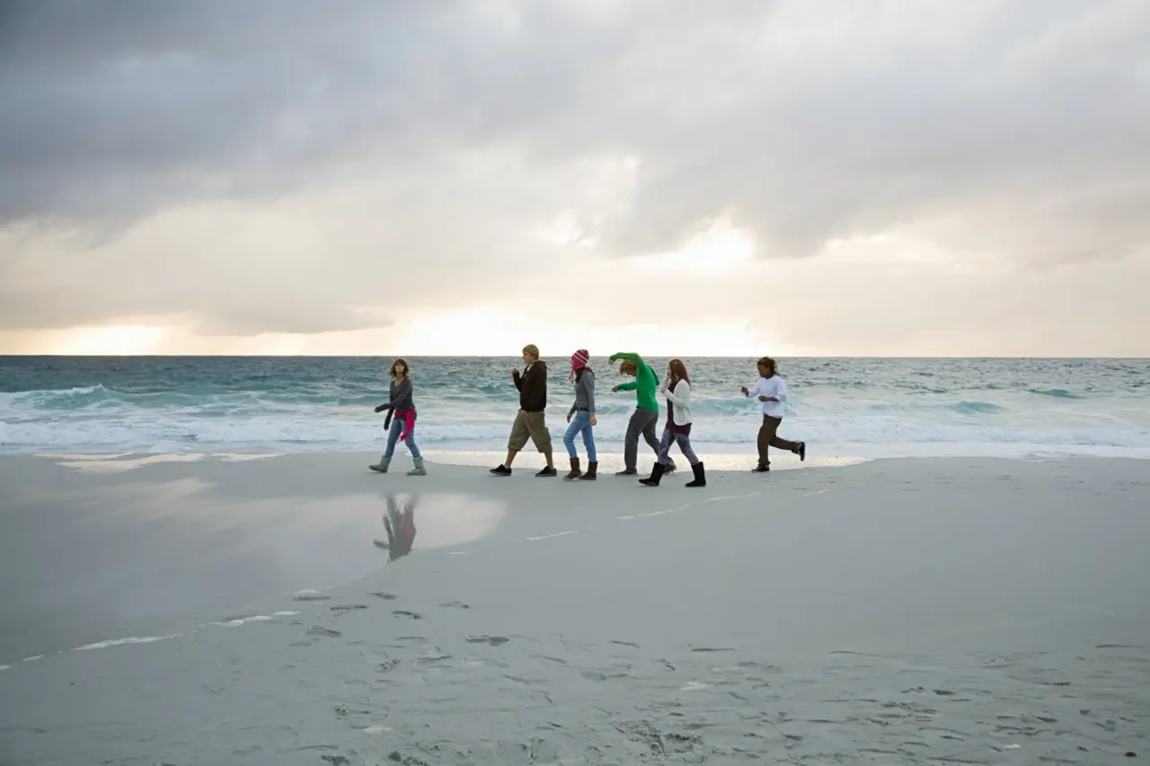A group of happy people walking on the beach