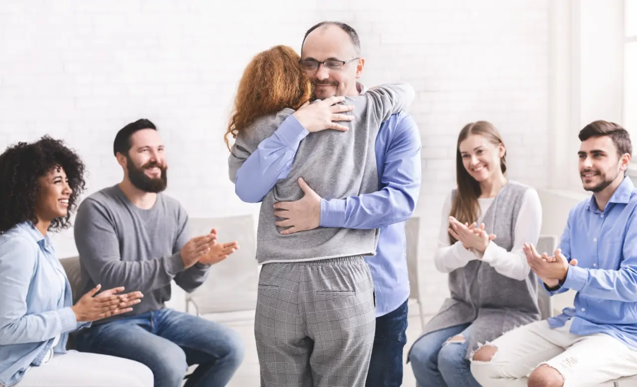 People hugging during a group rehab therapy session